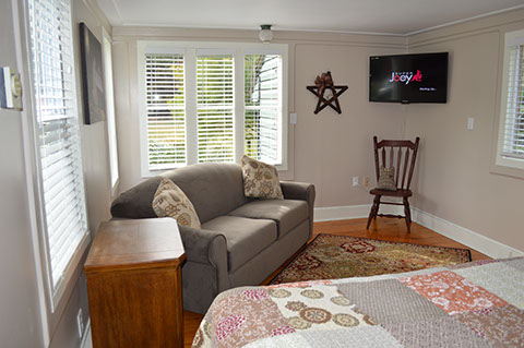A bed, sofa and TV is available in the guest cottage rental.